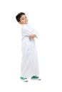 Arab boy smiling and acting cool with crossed hands, wearing white traditional Saudi Thobe and sneakers, on white isolated