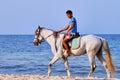 Arab boy on a white horse rides along the beach. Arabian youth sea rider in the middle East - Tunisia, Sousse, Africa 06 13 2019 Royalty Free Stock Photo