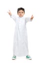 Arab boy winking and acting cool with crossed hands, wearing white traditional Saudi Thobe and sneakers, on white isolated