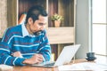 Arab businessman in casual clothes working in the office with laptop, paper, note and a cup of coffee on working table