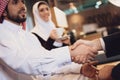 Arab businessman shakes hands with partner.