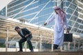 Arab businessmen and businessman playing tug of war on city back Royalty Free Stock Photo