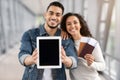 Arab Couple Demonstrating Digital Tablet With Black Screen While Standing In Airport