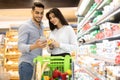 Arab Couple Using Smartphone Buying Food Shopping In Modern Supermarket Royalty Free Stock Photo