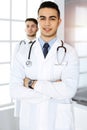 Arab doctor man standing with caucasian colleague in medical office or clinic. Diverse doctors team, medicine and