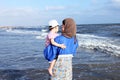 Arab egyptian muslim mother holding her baby girl on beach in egypt Royalty Free Stock Photo