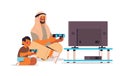 Arab father playing video games on game console with little son parenting fatherhood concept