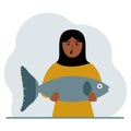 A arab female fisherman holds a large fish, proud of good fishing or hunting. Hobby, fishing concept. Royalty Free Stock Photo