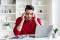 Arab Freelancer Guy Having Headache While Sitting At Desk In Home Office Royalty Free Stock Photo