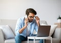 Arab Freelancer Man Talking On Cellphone And Working With Laptop At Home Royalty Free Stock Photo