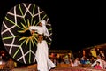 Arab male dancer performing in front of a crowd in Arabian deser
