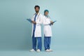 Arab Male And Female Doctor In Uniform Posing Over Blue Studio Background Royalty Free Stock Photo