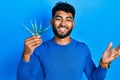 Arab man with beard holding picklock to unlock security door celebrating achievement with happy smile and winner expression with