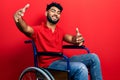 Arab man with beard sitting on wheelchair looking at the camera smiling with open arms for hug Royalty Free Stock Photo