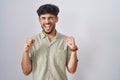 Arab man with beard standing over white background excited for success with arms raised and eyes closed celebrating victory Royalty Free Stock Photo