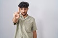 Arab man with beard standing over white background pointing with finger up and angry expression, showing no gesture Royalty Free Stock Photo