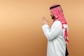 Arab man businessman in national clothes folded his hands in prayer, like, beige background. Dishdasha, kandora, thobe, middle Royalty Free Stock Photo