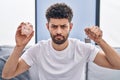 Arab man holding piggy bank and house keys depressed and worry for distress, crying angry and afraid Royalty Free Stock Photo