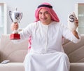 Arab man with prize and money on sofa Royalty Free Stock Photo