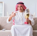 Arab man with prize and money on sofa Royalty Free Stock Photo