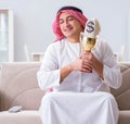 Arab man with prize and money on sofa Royalty Free Stock Photo