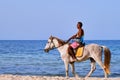 Arab man in sunglasses on a white horse rides along the beach. Arabian sea rider in the middle East - Tunisia, Sousse, Africa 06 Royalty Free Stock Photo