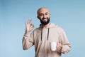 Arab man with tea showing okay sign