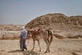 Arab man walking with his horse through the desert in Egypt. Royalty Free Stock Photo