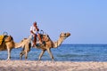 Arab man on a white camel rides along the beach. Arabian sea rider in the middle East - Tunisia, Sousse, Africa 06 13 2019 Royalty Free Stock Photo