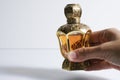 Arab perfume in a bottle held by hand, isolated in white background