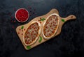 Arab pizza on a wooden stand. Scones with minced meat and pomegranate. Royalty Free Stock Photo