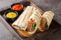 Arab Traditional Food Shawarma Rolled Sandwich with Sauce and vegetables closeup on the wooden board. Horizontal Royalty Free Stock Photo