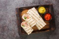Arab Traditional Food Shawarma Rolled Sandwich with Sauce and vegetables closeup on the wooden board. Horizontal top view Royalty Free Stock Photo