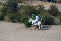 Arab with typical clothes from the area, riding on a donkey standing on the bank of the