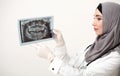 Saudi female dantist looking at teeth radiograph