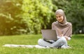 Arab woman freelancer working on laptop at park