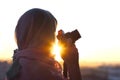 Arab Woman Photographer in a scarf taking picture using Camera on the sunset background. Royalty Free Stock Photo