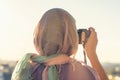 Arab Woman Photographer in a scarf taking picture using Camera on the sunset background. Halal travel concept Royalty Free Stock Photo