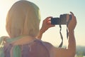 Arab Woman Photographer in a scarf taking picture using Camera on the sunset background. Halal travel concept Royalty Free Stock Photo