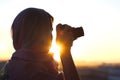 Arab Woman Photographer in a scarf taking picture using Camera on the sunset background. Royalty Free Stock Photo