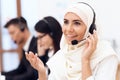 An Arab woman works in a call center. Arabian works at office. Royalty Free Stock Photo