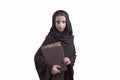 Arabic student wearing abaya, holding book..Arab young girl dressed in black abaya with books in her hands, girl student