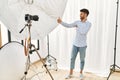 Arab young man posing as model at photography studio looking proud, smiling doing thumbs up gesture to the side Royalty Free Stock Photo