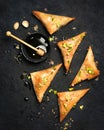 Arabe phyllo sweets. Feta cheese Phyllo Triangles pies with honey and pistachios, selective focus. Cooking sweets turkish, or