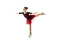 Portrait of little flexible girl, figure skater wearing stage attire posing isolated on white studio backgound. Concept