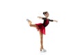 Portrait of little flexible girl, figure skater wearing stage attire posing isolated on white studio backgound. Concept