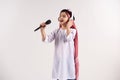 Arabian boy in keffiyeh with microphone sings karaoke Royalty Free Stock Photo