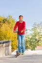 Arabian boy in red shirt stands on push-bicycle Royalty Free Stock Photo