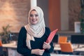 Arabian business woman holding a folder in modern startup office Royalty Free Stock Photo