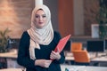 Arabian business woman holding a folder in modern startup office Royalty Free Stock Photo